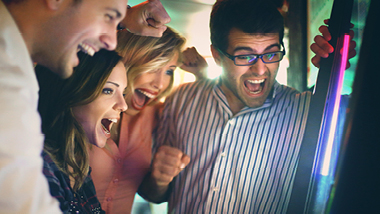 People cheering at slot machine